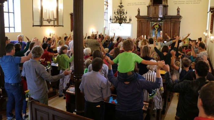 Eine Gruppe von Menschen feiert in einem Kirchenraum.