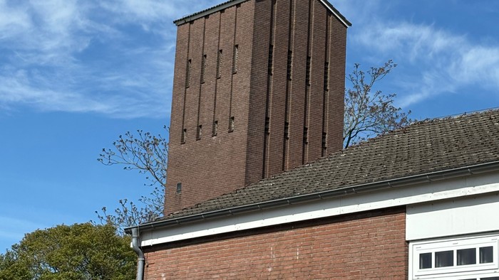 Hinterer Teil der Auferstehungskirche. Dahinter der Turm vor einem blauen Himmel mit Schleierwolken. 
