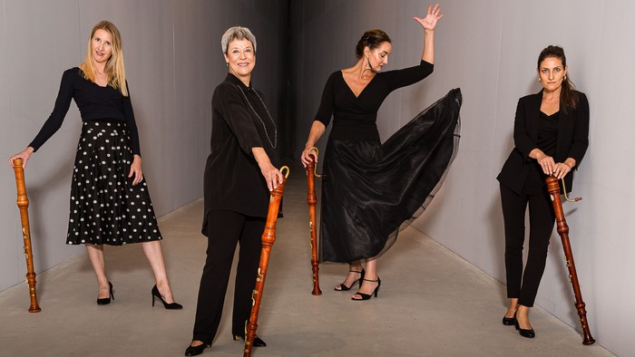 Fire kvinder i svart tøj med fløjter