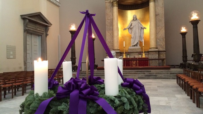 Alter i kirke med lys og grønne kranser