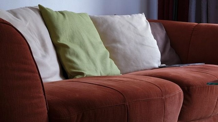 Lounge / Ein braunes Sofa mit Kissen