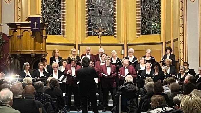 Ein Chor singt in einer Kirche vor einem großen Publikum