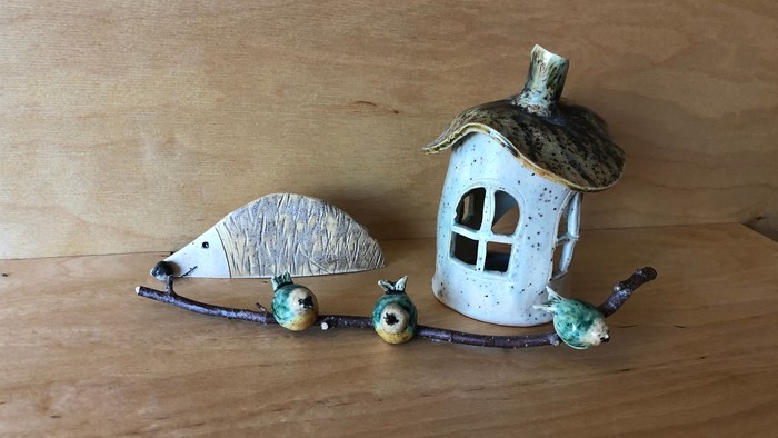 Verspieltes Keramikhaus mit Vögeln und Früchten auf einem Ast.