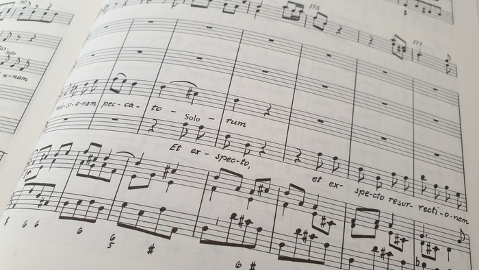 Nahaufnahme klassischer Notenblätter mit detaillierter musikalischer Notation und Liedtext für eine Vokalsolopassage.