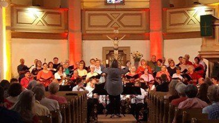 Kirchliche Zeremonie mit vielen Teilnehmern und großer Kronleuchter