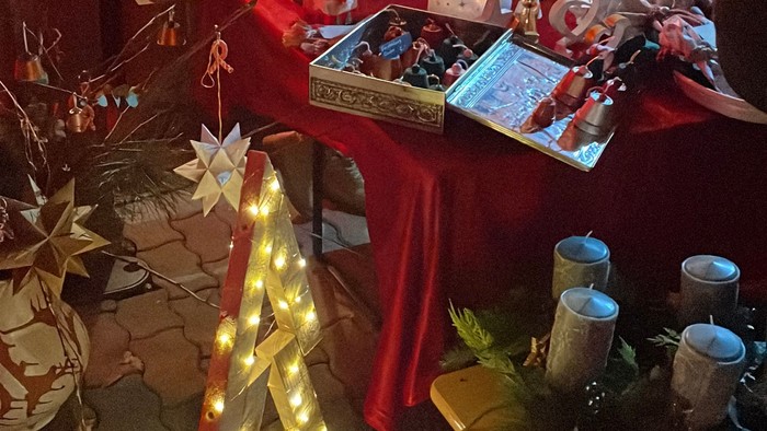 Weihnachtlicher Stand mit Lichterbaum und Geschenken