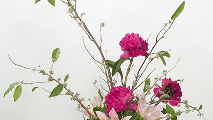 Un bouquet de fleurs colorées dans un vase noir sur une table blanche