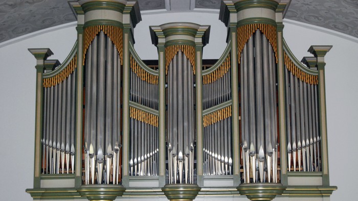Großes Kirchenorgel mit verzierten Pfeifen.