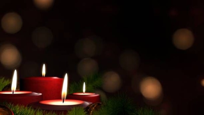 Drei brennende rote Kerzen auf grünem Hintergrund