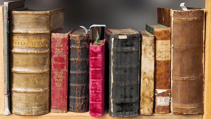 En række gamle og bragte boger på en bookshelf