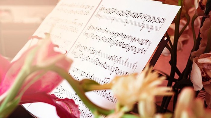 En blomsterstand foran noterblade med musiknoter