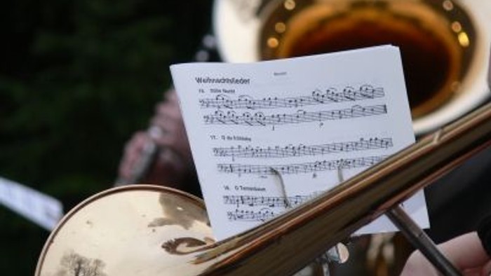 Ein Musiker hält eine Notenfolge für ein Blechblasinstrument