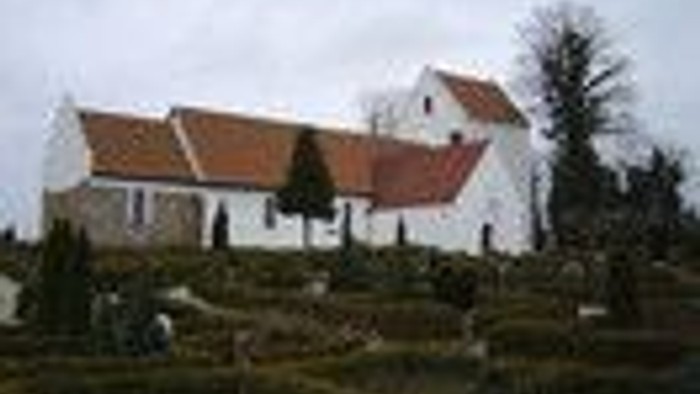 En stor, hvid villa med rødt tag og en stor have.