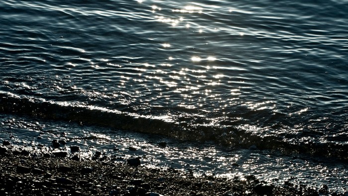 Strand med små bølger der ruller ind