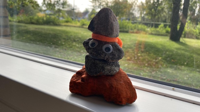En lille figur af en skibsfigur med hat og skjorte sidder på vindueskanten.