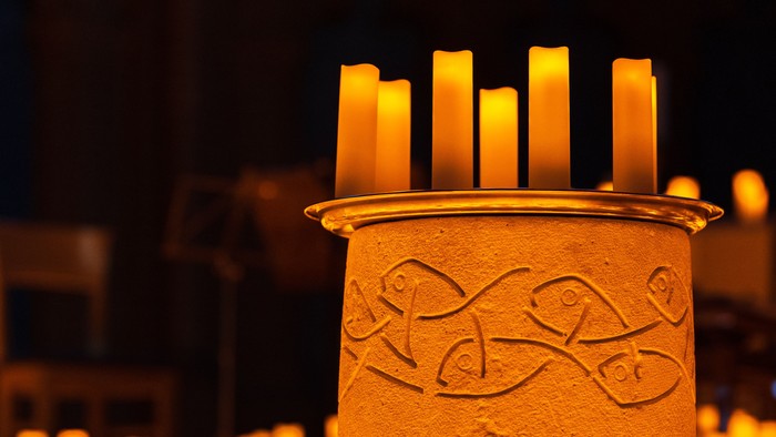 Taufbecken in der Apostel-Paulus-Kirche, umgeben von Lichtern