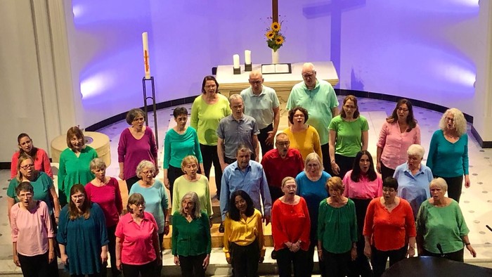 Eine Gruppe von Erwachsenen und Kindern posiert vor einem Altar in einer Kirche.