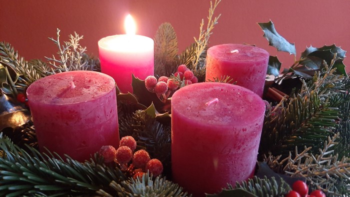 Weihnachtsdekoration mit vier Kerzen und Tannenzweigen