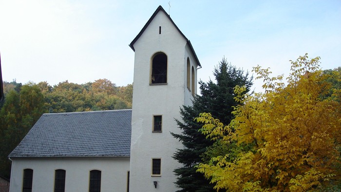 Weißes Gebäude mit Turm neben Bäumen