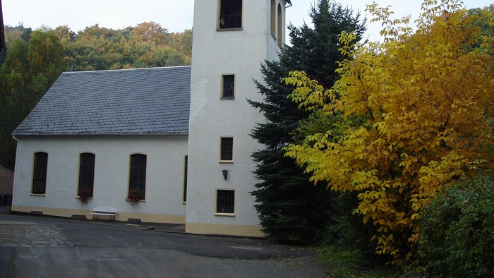 Weißes Gebäude mit Turm neben Bäumen
