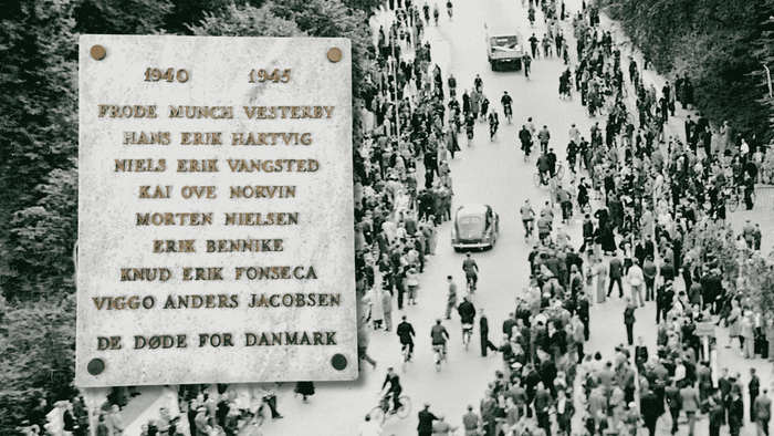 Sort-hvid folkemængde, der mindes danske modstandskæmpere og ofre under Anden Verdenskrig med indskrevne navne.
