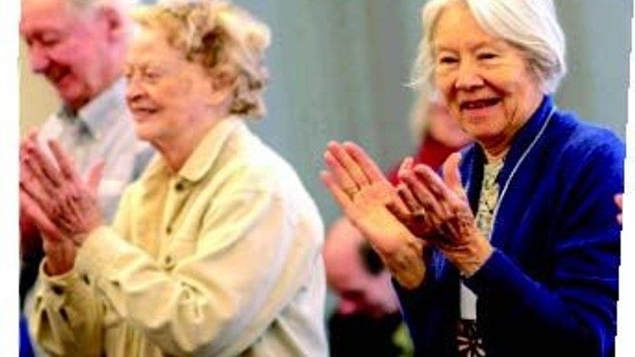 En gruppe ældre personer klapper i hænder.