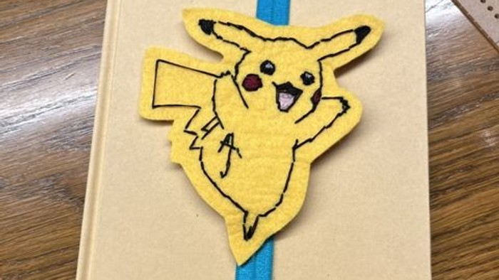 En bog med et Pikachu-mærke og blå bogmærke.