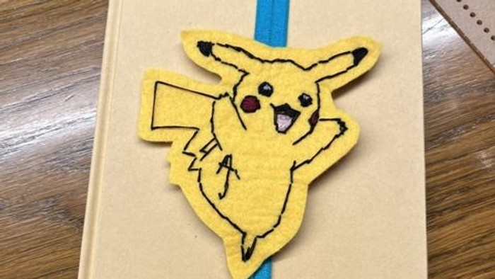En bog med et Pikachu-mærke og blå bogmærke.