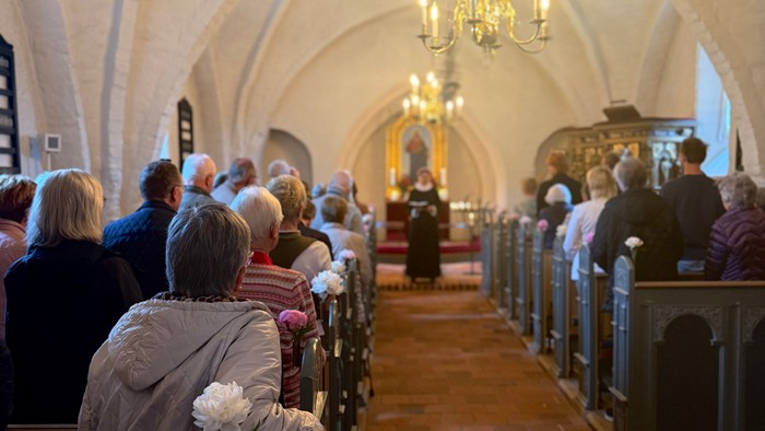 En kirke med høje buer og folk på bænkene