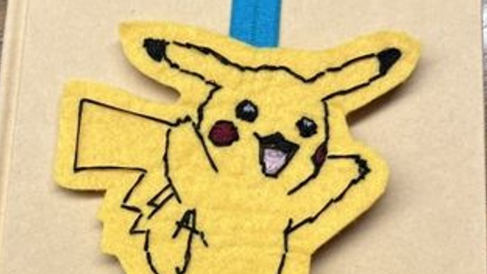 En bog med et Pikachu-mærke og blå bogmærke.