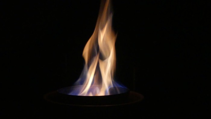 Ein einzelner Flammenstoß auf schwarzem Hintergrund.