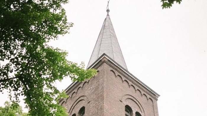 Der Kirchturm aus Ziegeln ragt hoch in den Himmel