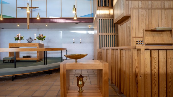 Indre del af kirke med træindretninger og lysende lys.