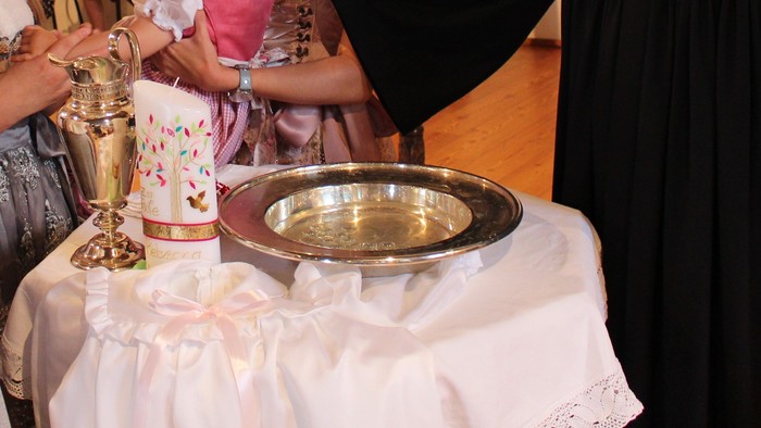 Ein Priester segnet ein Baby in einer Kirche