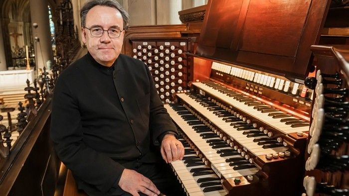 Mand sidder ved et orgel i kirke