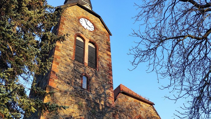 Gotische Kirche mit hohem Turm und Uhr.