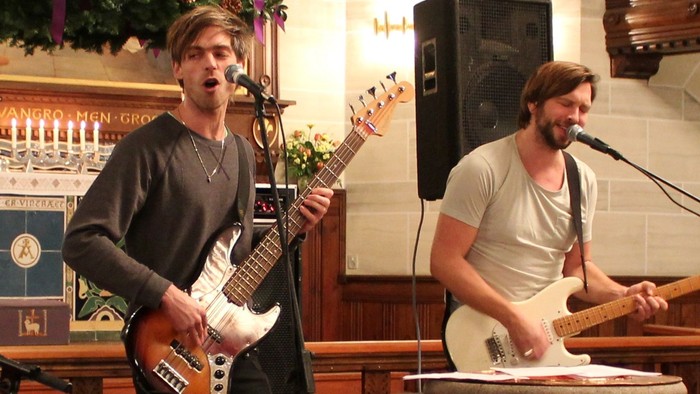 To mænd spiller guitarer i kirke
