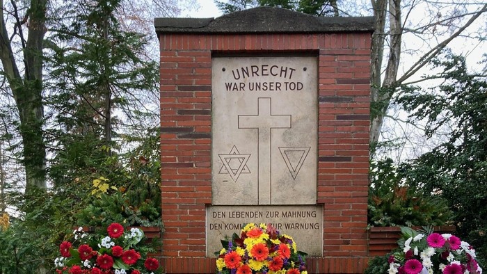 Gedenkstätte mit Blumengebinden und Inschrift