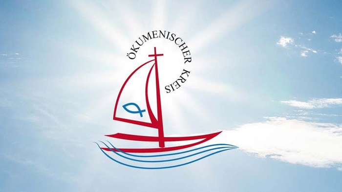Das Bild zeigt ein Segelboot mit christlichem Symbol vor einem Sonnenuntergang.