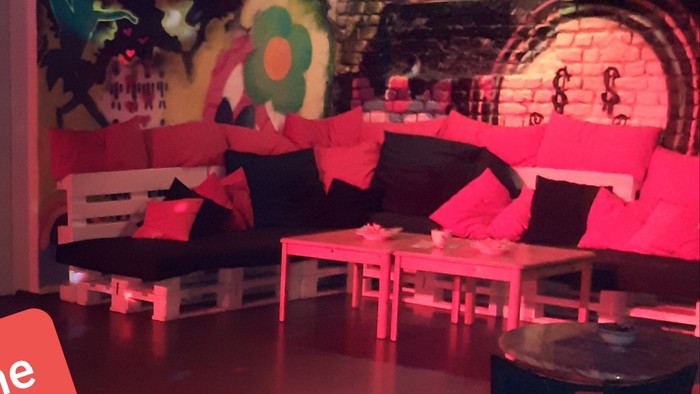Willkommen im stylischen Partyraum mit bunten Möbeln und Diskokugel.