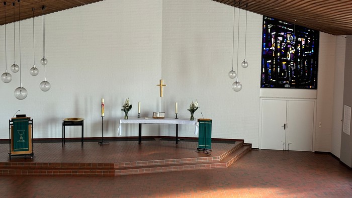 Moderne Kirche mit Holzaltar, farbigen Fenstern und modernen Lichtern