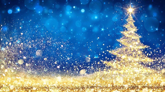 En skinnende juletree mod en blå himmel med stjerner og lyseflimmer.