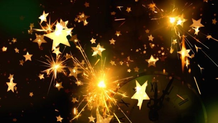 Lyse stjerner og gnister mod mørk baggrund