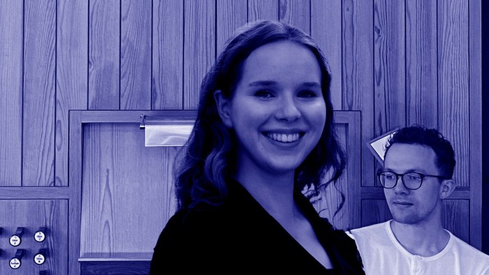 En kvinde og en mand står sammen i et rum med trævægge.