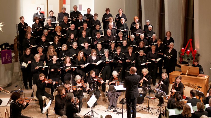 Ein großer Chor und Orchester treten in einem Konzert auf
