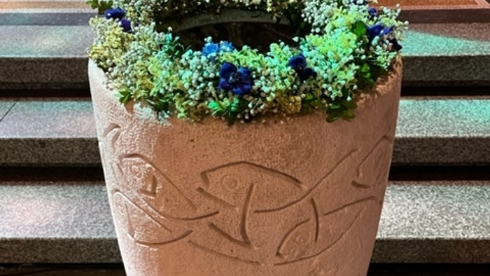 Taufstein mit Blumenkranz in der Apostel-Paulus-Kirche