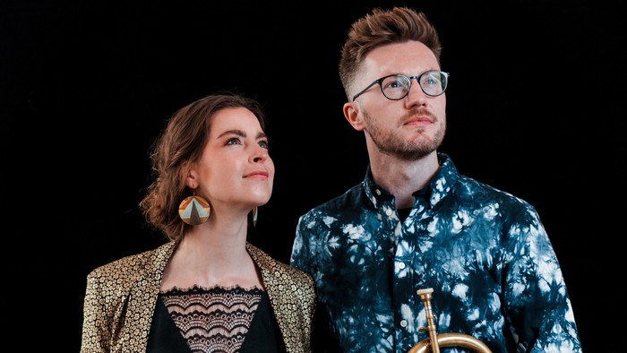 En mand og en kvinde står sammen med en trombone.