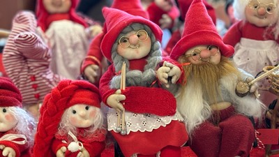 En gruppe nisser i røde kapper og klæder sidder sammen.