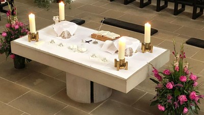 Ein Altar mit Kerzen, Blumen und religiösen Gegenständen