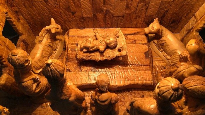 Die Krippe zeigt Jesus mit Maria und Josef in einer Holzhütte.